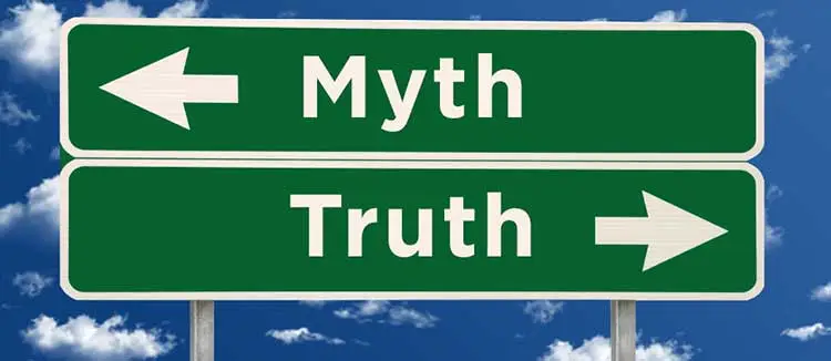 Two green directional road signs pointing in opposite directions labeled Myth and Truth against a blue sky